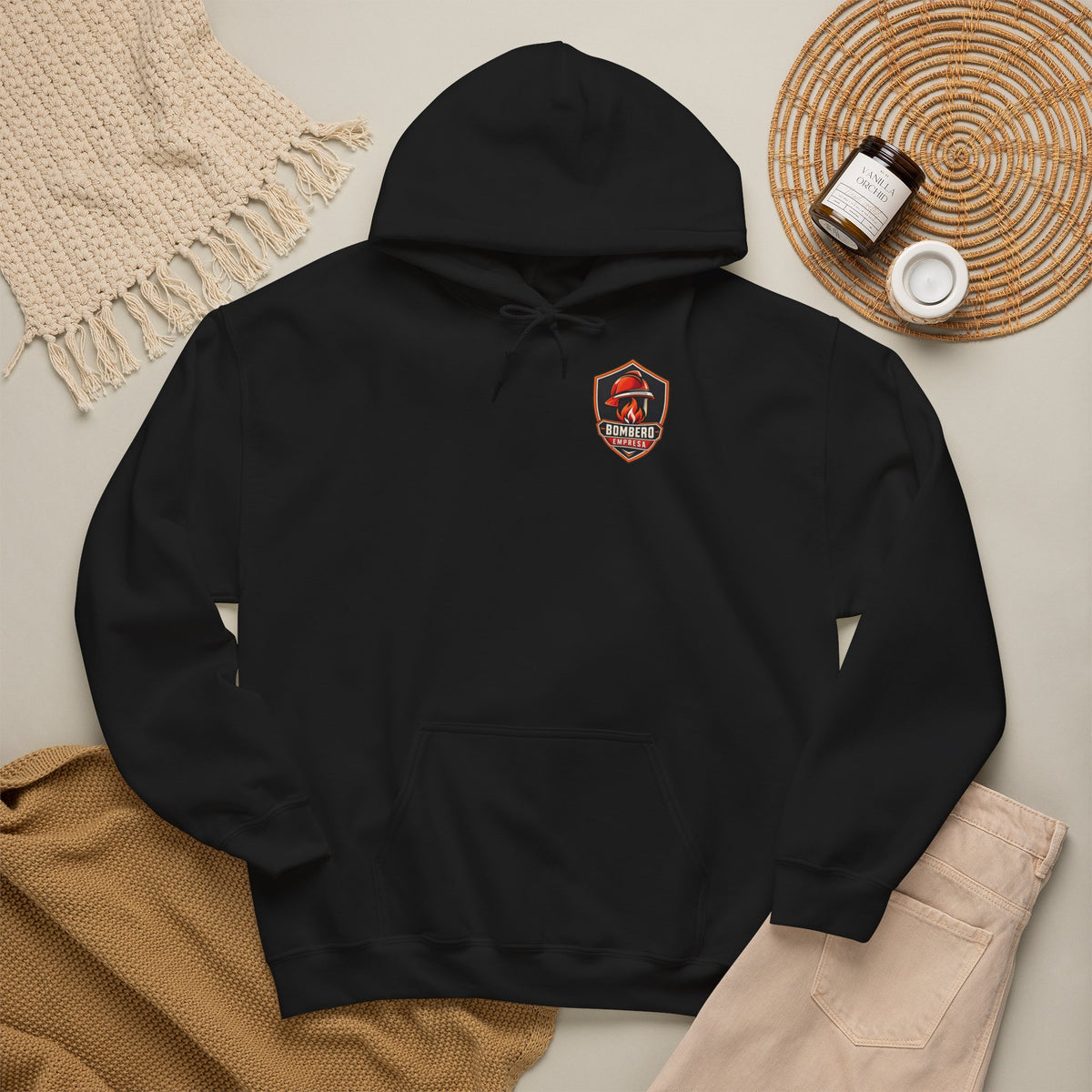 Sudadera negra con capucha y escudo de Bombero Empresa presentada sobre fondo decorado